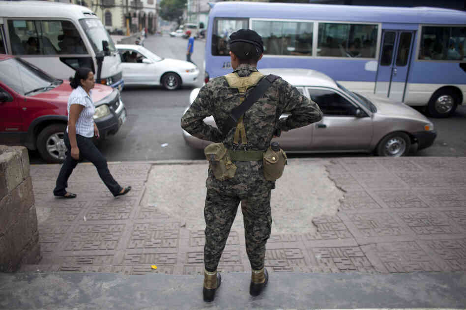 A soldier watches over public transport users during an operation in