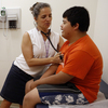 Families soon will be able to sign up for new health insurance options through the Affordable Care Act. In Washington, D.C., Dr. Cheryl Focht of Mary's Center performs a checkup of Jayson Gonzalez, 16, while his mother, Elizabeth Lopez, looks on. Families soon will be able to sign up for new health insurance options through the Affordable Care Act. In Washington, D.C., Dr. Cheryl Focht of Mary's Center performs a checkup of Jayson Gonzalez, 16, while his mother, Elizabeth Lopez, looks on.