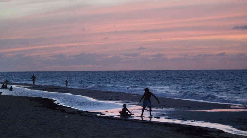 Children play on a beach in San Juan, Puerto Rico. The Puerto Rican government hopes that convincing wealthy investors to relocate here will boost the island's economy. Children play on a beach in San Juan, Puerto Rico. The Puerto Rican government hopes that convincing wealthy investors to relocate here will boost the island's economy.