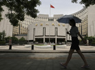 A woman walks past the headquarters of the People's Bank of China (PBOC), the central bank, in Beijing. A woman walks past the headquarters of the People's Bank of China (PBOC), the central bank, in Beijing.