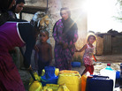Refugees fill cans with water inside a camp in Baalbek, Lebanon, for Syrians who have fled the fighting in their country. Refugees fill cans with water inside a camp in Baalbek, Lebanon, for Syrians who have fled the fighting in their country.