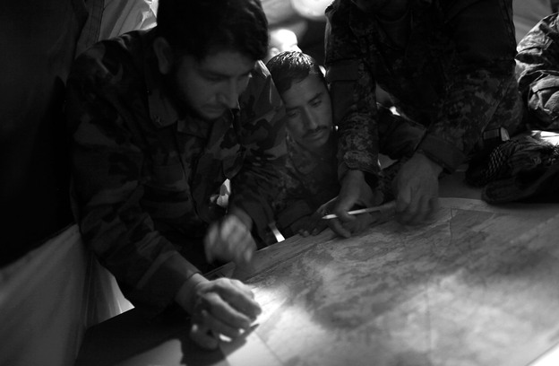ANA soldiers plot coordinates on a map with the help of their American trainers. (NPR)