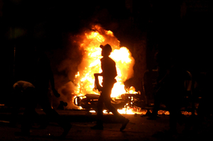 A protester runs past a fire raging during clashes in Giza early Wednesday.