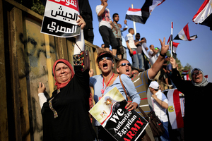 Morsi opponents chant slogans during a protest outside the presidential palace, in Cairo. The poster with partial translation of Arabic reads, "We support the Egyptian military."