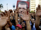 Egyptian supporters of the Muslim Brotherhood hold pictures of deposed President Mohammed Morsi in Cairo on Friday. Egyptian supporters of the Muslim Brotherhood hold pictures of deposed President Mohammed Morsi in Cairo on Friday.