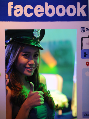 A model poses for photos next to a life-size makeshift Facebook browser in the Philippines. A model poses for photos next to a life-size makeshift Facebook browser in the Philippines.