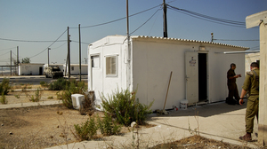A white metal trailer serves as the makeshift synagogue at the West Bank outpost of an all-ultra-Orthodox Israeli military platoon.