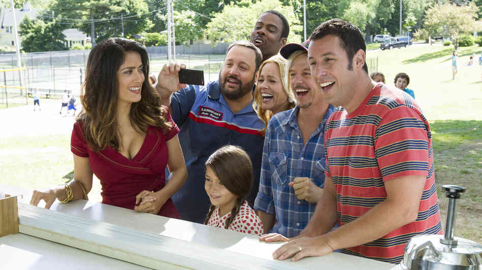 Improbably or not, Salma Hayek (left) and Adam Sandler (far right) are a couple again in Grown Ups 2. Billed as a comedy, the film also features Kevin James, Alexys Nicole Sanchez, Chris Rock, Maria Bello and David Spade, who in this scene are all pretending to laugh at something that in all likelihood involves poo. Improbably or not, Salma Hayek (left) and Adam Sandler (far right) are a couple again in Grown Ups 2. Billed as a comedy, the film also features Kevin James, Alexys Nicole Sanchez, Chris Rock, Maria Bello and David Spade, who in this scene are all pretending to laugh at something that in all likelihood involves poo.
