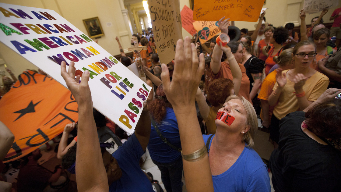 Opponents — dressed in blue — and supporters — wearing orange — of abortion rights rally in the State Capitol rotunda Friday before the vote on a set of sweeping abortion restrictions.