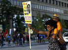 A woman, who refused to be identified, carries a young boy on her shoulders as she participates in a rally Sunday in Baltimore protesting the acquittal of George Zimmerman in the Florida shooting death of teenager Trayvon Martin. A woman, who refused to be identified, carries a young boy on her shoulders as she participates in a rally Sunday in Baltimore protesting the acquittal of George Zimmerman in the Florida shooting death of teenager Trayvon Martin.