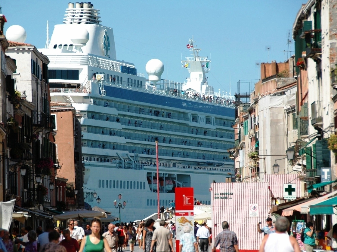 A massive cruise ships towers over Venice. Some 650 cruise ships now visit the Italian city annually, and critics say they threaten the city's fragile architecture.