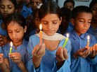 Indian school children hold candles as they pay tribute to school children who died from food poisoning in Saran district of Bihar state. Indian school children hold candles as they pay tribute to school children who died from food poisoning in Saran district of Bihar state.