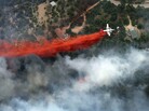 An aircraft lays down a line of fire retardant between a wildfire and homes in the dry, densely wooded Black Forest area northeast of Colorado Springs, Colo., on June 13. An aircraft lays down a line of fire retardant between a wildfire and homes in the dry, densely wooded Black Forest area northeast of Colorado Springs, Colo., on June 13.
