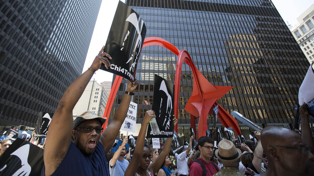 A man holds up a sign at the "Justice for Trayvon" rally in downtown Chicago on Saturday. (AP)