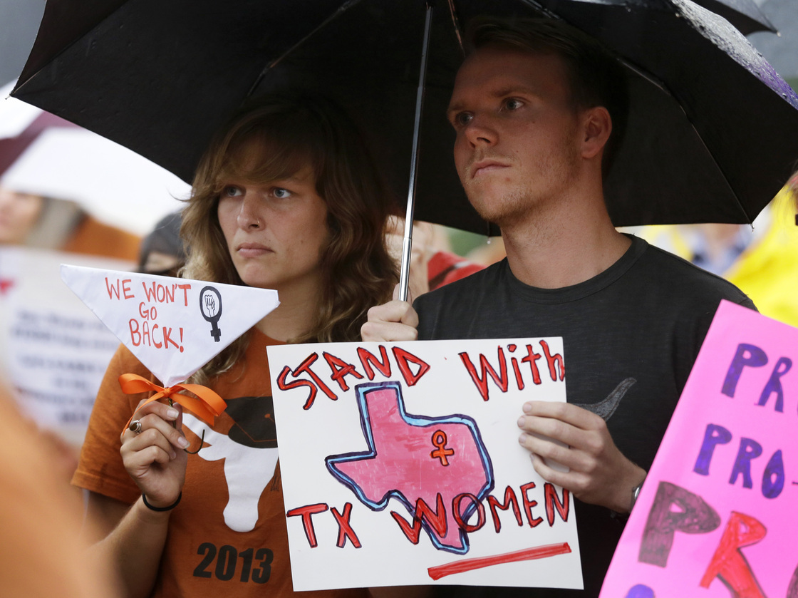 Becca Besaw of Austin, Texas, and Christopher Robertson of Fort Worth, Texas, protest the state's new law restricting access to abortion at a rally in Dallas on July 15.