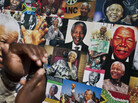 A well-wisher uses his phone to take a picture of a banner of photos of Nelson Mandela outside the Mediclinic Heart Hospital in Pretoria, where the former South African president is being treated. A well-wisher uses his phone to take a picture of a banner of photos of Nelson Mandela outside the Mediclinic Heart Hospital in Pretoria, where the former South African president is being treated.