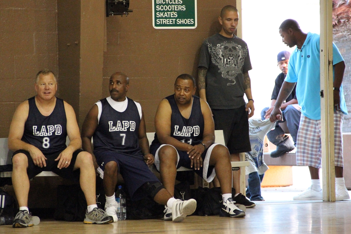 Los Angeles police officers take a break during a basketball game with residents of the Nickerson Gardens housing project in July 2011. Violent crime at Nickerson Gardens and two nearby housing projects has fallen by almost half since 2010.