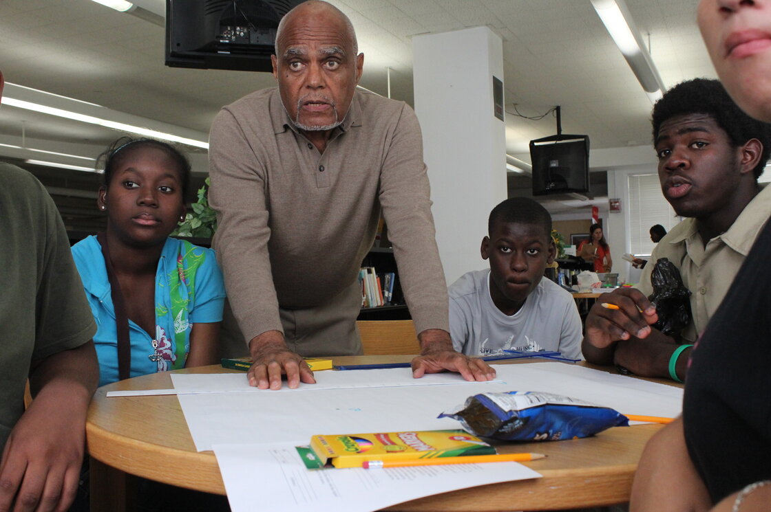 Bob Moses works with Jennifer Augustine, Guitoscard Denize, Darius Collins and other students who are part of this Algebra Project classroom. It's one of several student cohorts across the country where students who've struggled with math get to college-level by the end of high school.