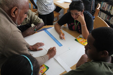 Moses shows students how to measure slopes using a ruler made by the students. His Algebra Project classroom model uses a lot of hands-on tools to help kids make math less abstract.