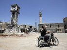 A Syrian man rides his motorbike past the Sunni Grand mosque on Thursday in the city of Qusayr, in Syria's central Homs province. A Syrian man rides his motorbike past the Sunni Grand mosque on Thursday in the city of Qusayr, in Syria's central Homs province.