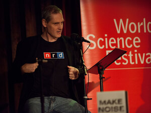 Puzzle guru John Chaneski rocks his famous "nrd" shirt at the World Science Festival taping of Ask Me Another at The Bell House in Brooklyn. Puzzle guru John Chaneski rocks his famous "nrd" shirt at the World Science Festival taping of Ask Me Another at The Bell House in Brooklyn.