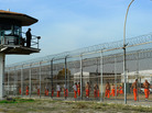 A California Department of Corrections officer looks on as inmates at Chino State Prison exercise in the yard in 2010. A California Department of Corrections officer looks on as inmates at Chino State Prison exercise in the yard in 2010.