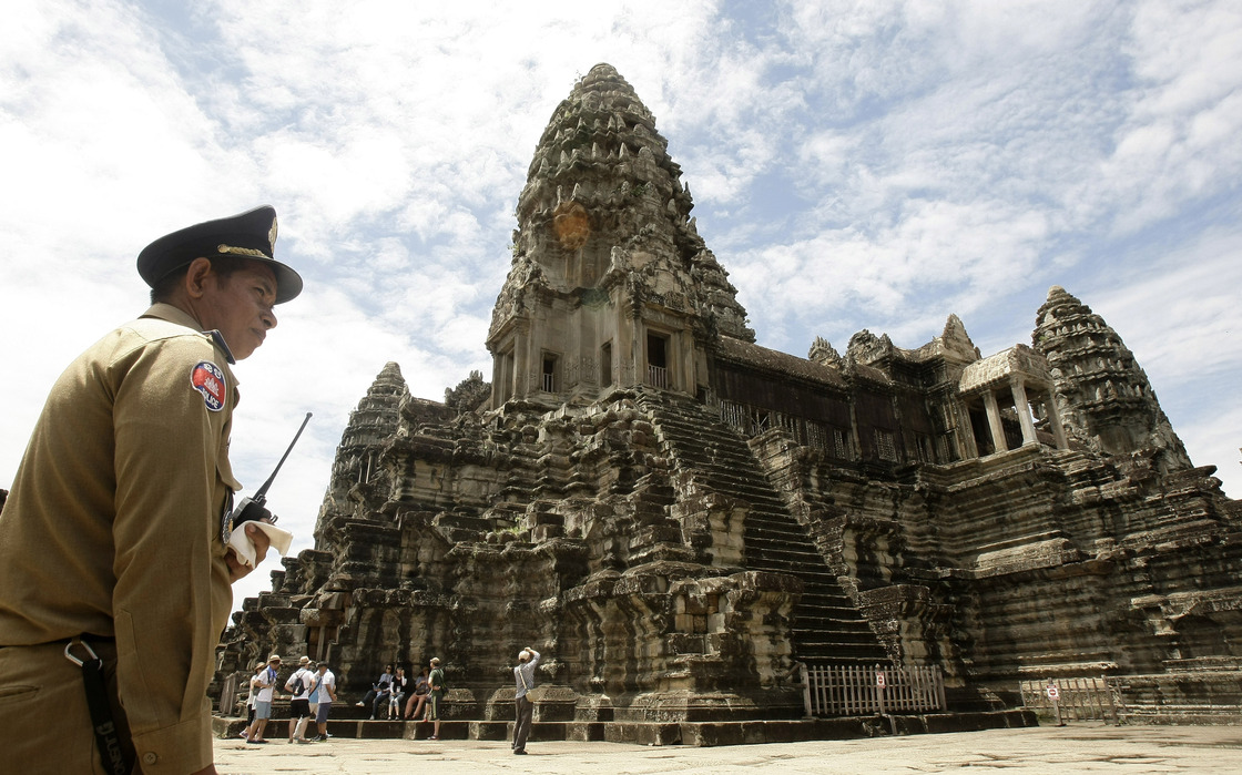 A police officer guards Cambodia's famed temple of Angkor Wat. The powerful city-state collapsed in 1431 after suffering through two decades of droughts.