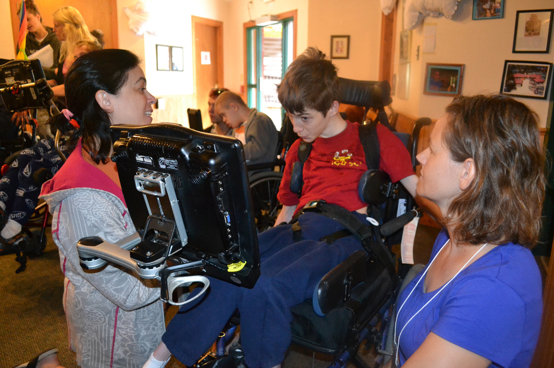 Speech-language pathologists Jill Tullman (left) and Mendi Carroll (right) work with Bryce Vernon at Talking with Technology Camp in Empire, Colo., on July 25.
