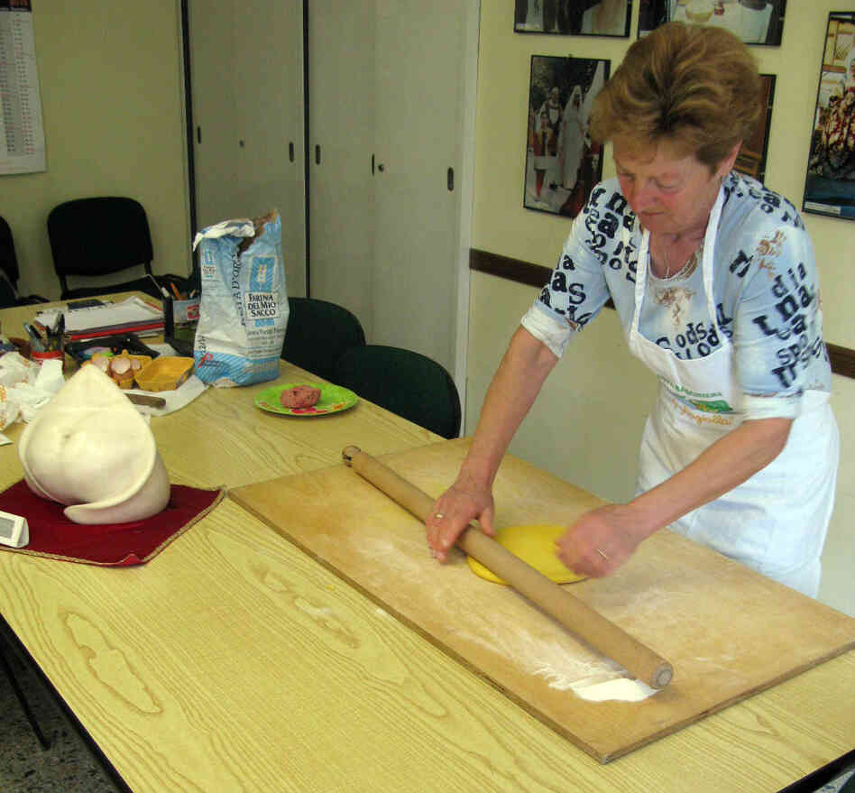 Grazia Battistini, 63, has been been making tortellini as a sfoglina for about 50 years. A statue of the ideal tortellino shape sits in the foreground. Grazia Battistini, 63, has been been making tortellini as a sfoglina for about 50 years. A statue of the ideal tortellino shape sits in the foreground.