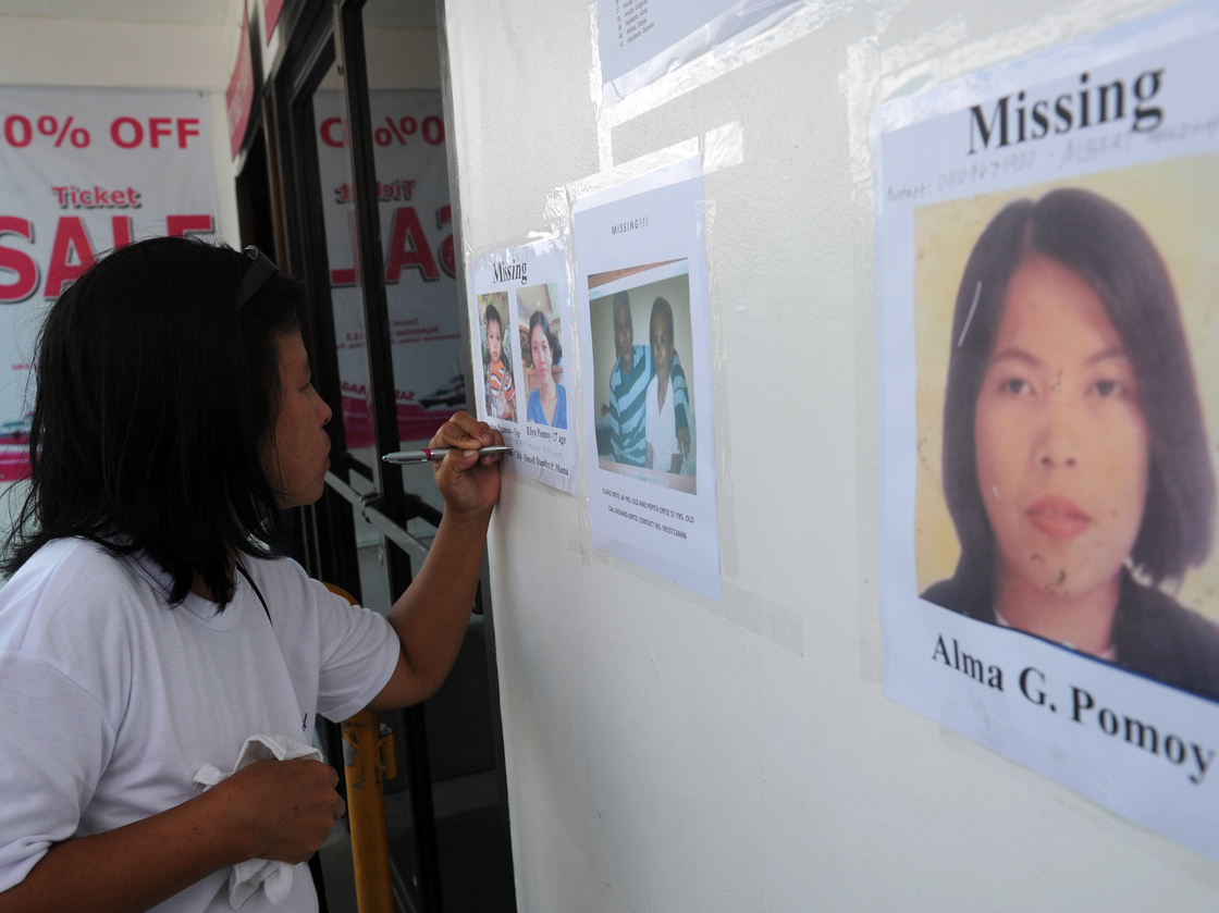 A relative of one of the missing passengers writes down contact numbers on Sunday at the office of the ferry involved in a collision, in Cebu City.