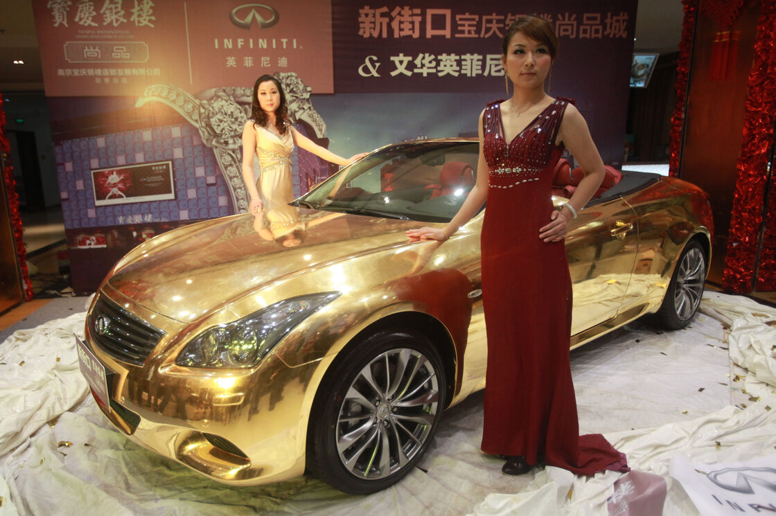 Models pose with a gold-plated Infiniti luxury sports car on display at a jewelry store in Nanjing, in east China's Jiangsu province, in 2011. Models pose with a gold-plated Infiniti luxury sports car on display at a jewelry store in Nanjing, in east China's Jiangsu province, in 2011.