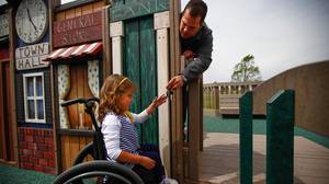 Brooklyn Fisher, who has spina bifida, plays with her father, Jonny Fisher, at the playground.