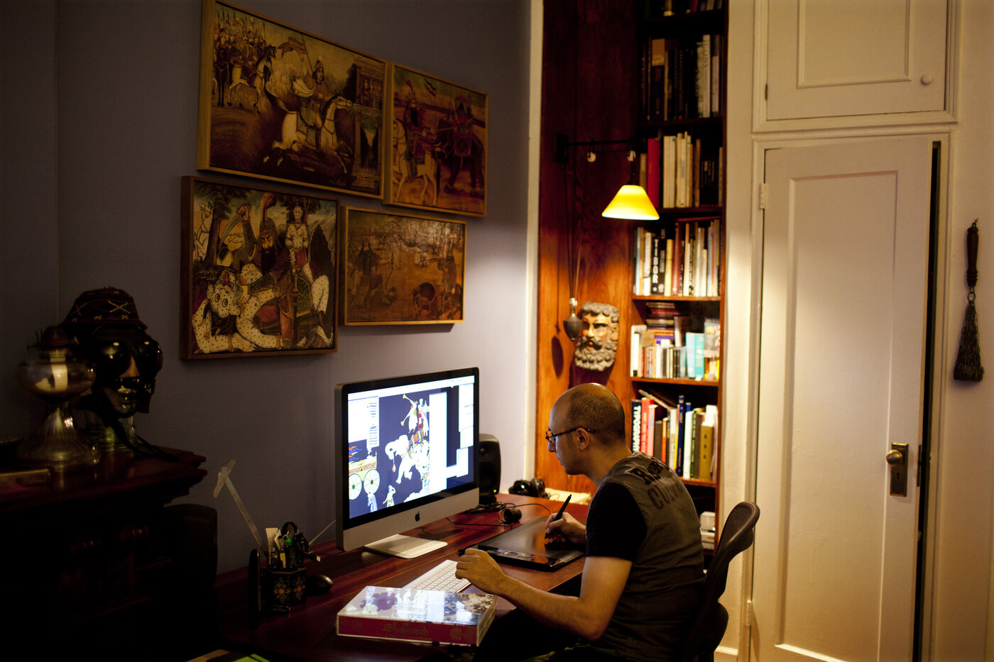 The wall above Rahmanian's desk is adorned with wooden reliefs of stories from the Shahnameh, depicted in a style known as Ghahve Khane. Rahmanian says looking up at the images while he worked would rest his eyes and offered a reprieve from the computer screen. The wall above Rahmanian's desk is adorned with wooden reliefs of stories from the Shahnameh, depicted in a style known as Ghahve Khane. Rahmanian says looking up at the images while he worked would rest his eyes and offered a reprieve from the computer screen.