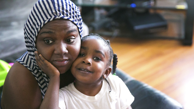 Carmesha Rogers snuggles with her 4-year-old daughter, Kasharee, on Aug. 22, in Muskegon, Mich. Rogers sustained a gunshot wound to the head on July 9 after removing several neighborhood children from a gunbattle's line of fire. Rogers says her only thought was: 'Just get the kids out the way. 'Cause I'd want someone to do that for my kids.' (Image credit: Mlive.com/Landov)