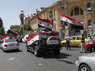 Vehicles carrying Syria's national flag and playing songs in support of President Bashar Assad drive through the streets of Damascus on Wednesday. Vehicles carrying Syria's national flag and playing songs in support of President Bashar Assad drive through the streets of Damascus on Wednesday.