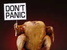 A prepared turkey holding a sign that reads "Don't Panic". A prepared turkey holding a sign that reads "Don't Panic".