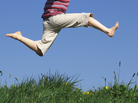 A boy jumps above a grassy field A boy jumps above a grassy field