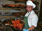 Roel Basalm Alim, a cook at Restaurante BotÃn, displays a plate of cochinillo asado, or roast suckling pig. Roel Basalm Alim, a cook at Restaurante BotÃn, displays a plate of cochinillo asado, or roast suckling pig.
