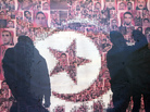 Tunisians are silhouetted Jan. 13 behind a poster of those who died in the revolution that overthrew an authoritarian president and started the Arab Spring. More than two years after the revolution, Tunisia is struggling with high unemployment and rising violence in its politics. Tunisians are silhouetted Jan. 13 behind a poster of those who died in the revolution that overthrew an authoritarian president and started the Arab Spring. More than two years after the revolution, Tunisia is struggling with high unemployment and rising violence in its politics.