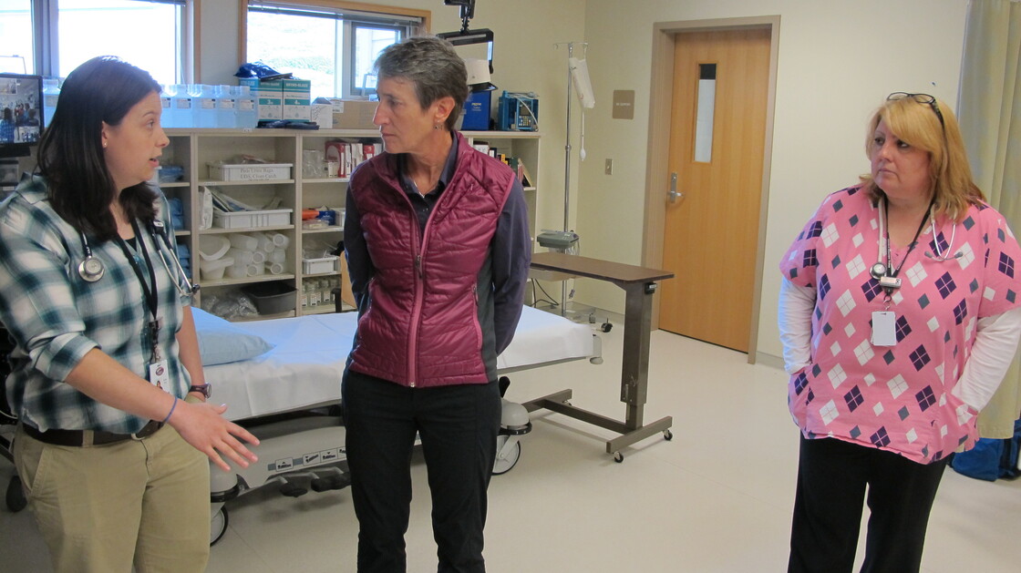 Bonita Babcock (right) looks on as a physician assistant at the clinic in King Cove, Alaska, explains to Interior Secretary Sally Jewell how a road from King Cove to Cold Bay would improve health care.