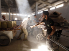 A rebel fighter inspects purchases made by civilians as they cross through a building near the front lines in Aleppo, in northern Syria, on Monday. The city has been divided for more than a year, with the rebels holding the eastern part and government troops holding the west. A rebel fighter inspects purchases made by civilians as they cross through a building near the front lines in Aleppo, in northern Syria, on Monday. The city has been divided for more than a year, with the rebels holding the eastern part and government troops holding the west.