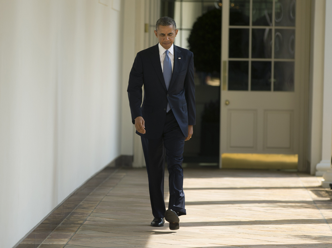 President Obama walks along the West Wing Colonnade towards the Oval Office of the White House on Tuesday.