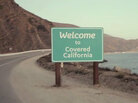 A sign in a TV ad welcomes Californians to insurance coverage. A sign in a TV ad welcomes Californians to insurance coverage.