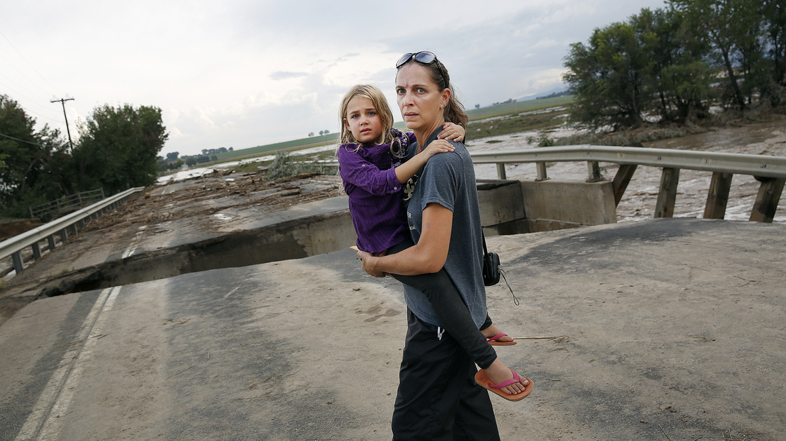 Samantha Kinzig of Longmont, Colo., and her daughter Isabel, 5, took a close look at a damaged bridge in Longmont Friday. Heavy rains that fueled widespread flooding in numerous Colorado towns have eased, but forecasters predict more on Saturday and Sunday.