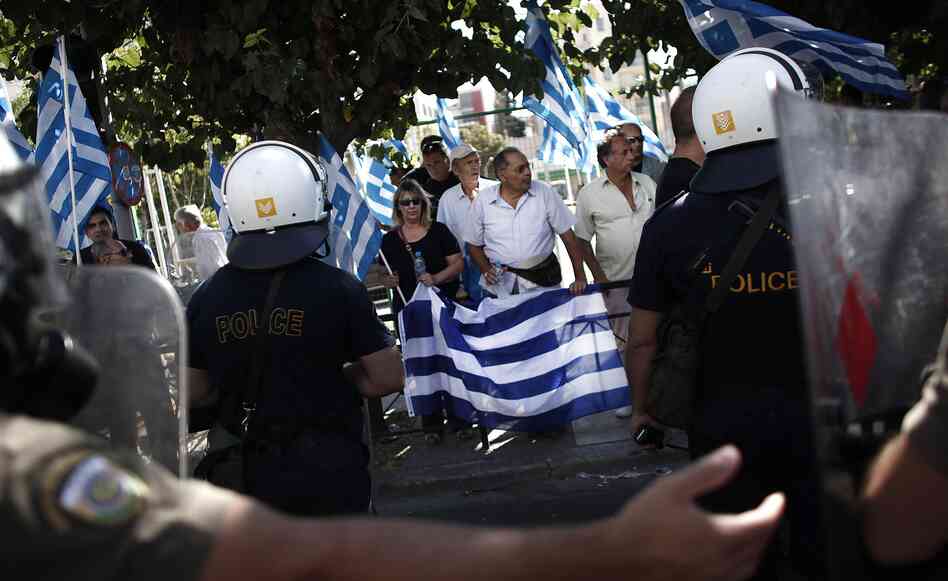 Riot police try to move supporters of the Golden Dawn party during a protest in solidarity of the arrested lawmakers in Athens on Saturday. Riot police try to move supporters of the Golden Dawn party during a protest in solidarity of the arrested lawmakers in Athens on Saturday.