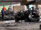 Iraqis look at the site of a car bomb attack in Baghdad, where at least 10 car bombs were detonated during the city's rush hour Monday. Iraqis look at the site of a car bomb attack in Baghdad, where at least 10 car bombs were detonated during the city's rush hour Monday.