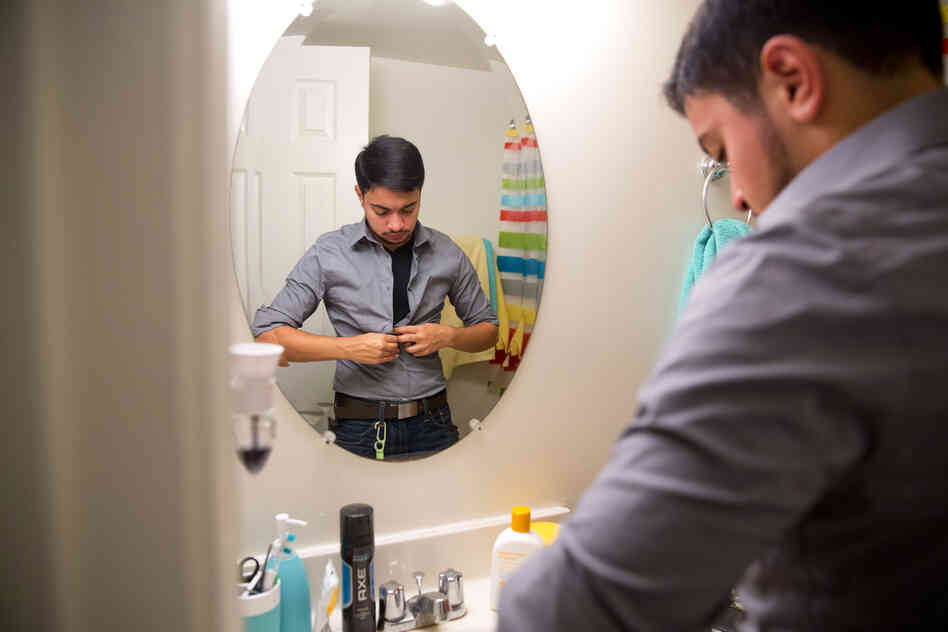 Younes dresses for work in the morning. He says that while telling his story will be his way of putting himself out there, that doesn't make it 