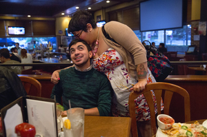 Younes' sister gives him a kiss during his birthday party.
