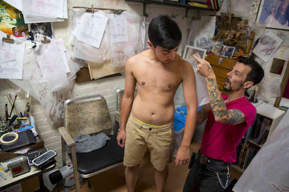 Younes lets Paul Roe, owner and artist at Britishink Tattoos in Washington, D.C., outline his body for a preliminary tattoo design. Younes plans to receive a fairly elaborate tattoo, including a lion and a sun, that will cover the majority of his body. The lion and the sun are two symbols often used in Iranian culture and have ties to Islam. Younes' middle name, Haidar, also means lion.