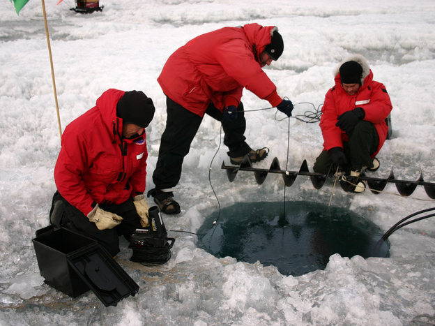 John Priscu, Phil Lee and Mike Lizotte use an underwater camera to check the progress of a hole being melted on Lake Bonney, Antarctica, in 2008. (Image credit: National Science Foundation)